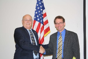 Mitch Able (l), chapter president, congratulates Nichols following his speech at the July meeting.